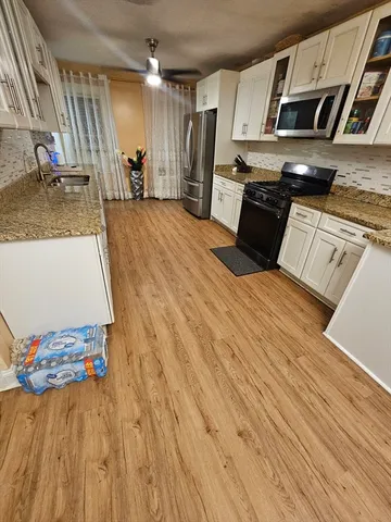 a kitchen with stainless steel appliances granite countertop a sink dishwasher stove and refrigerator