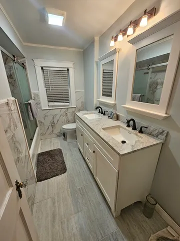 a spacious bathroom with a double vanity sink a mirror and a bathtub