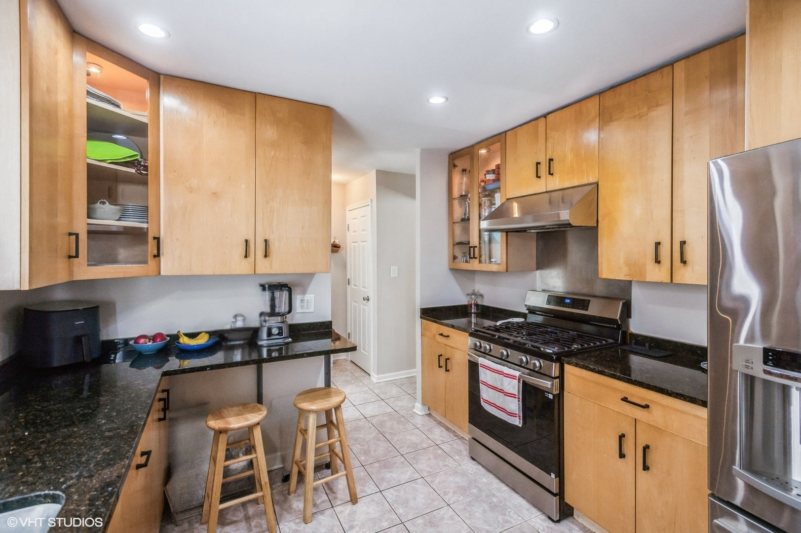 10021 Frontage Road, Unit F Skokie, IL 60077 - Photo 12 of 25 a kitchen with granite countertop a stove a sink and a refrigerator