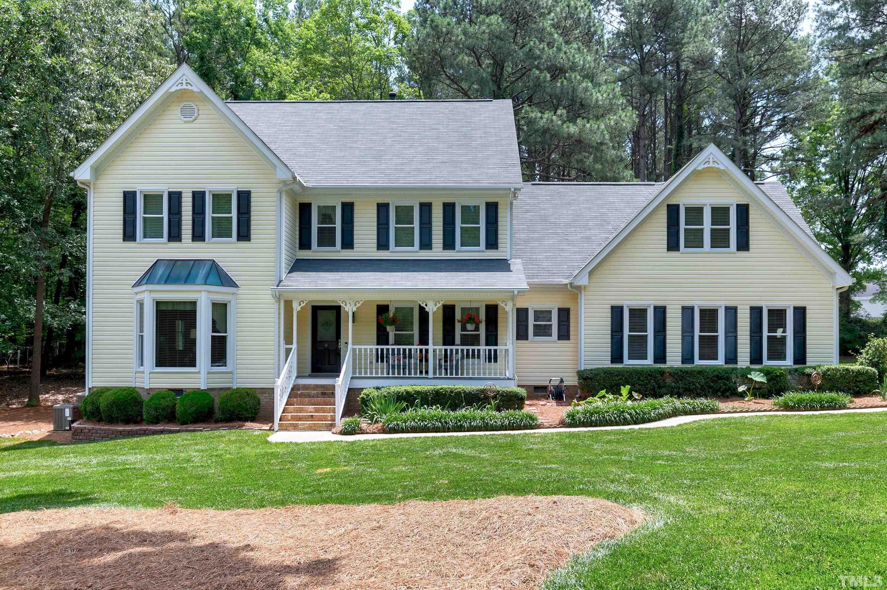 a front view of a house with a garden and plants
