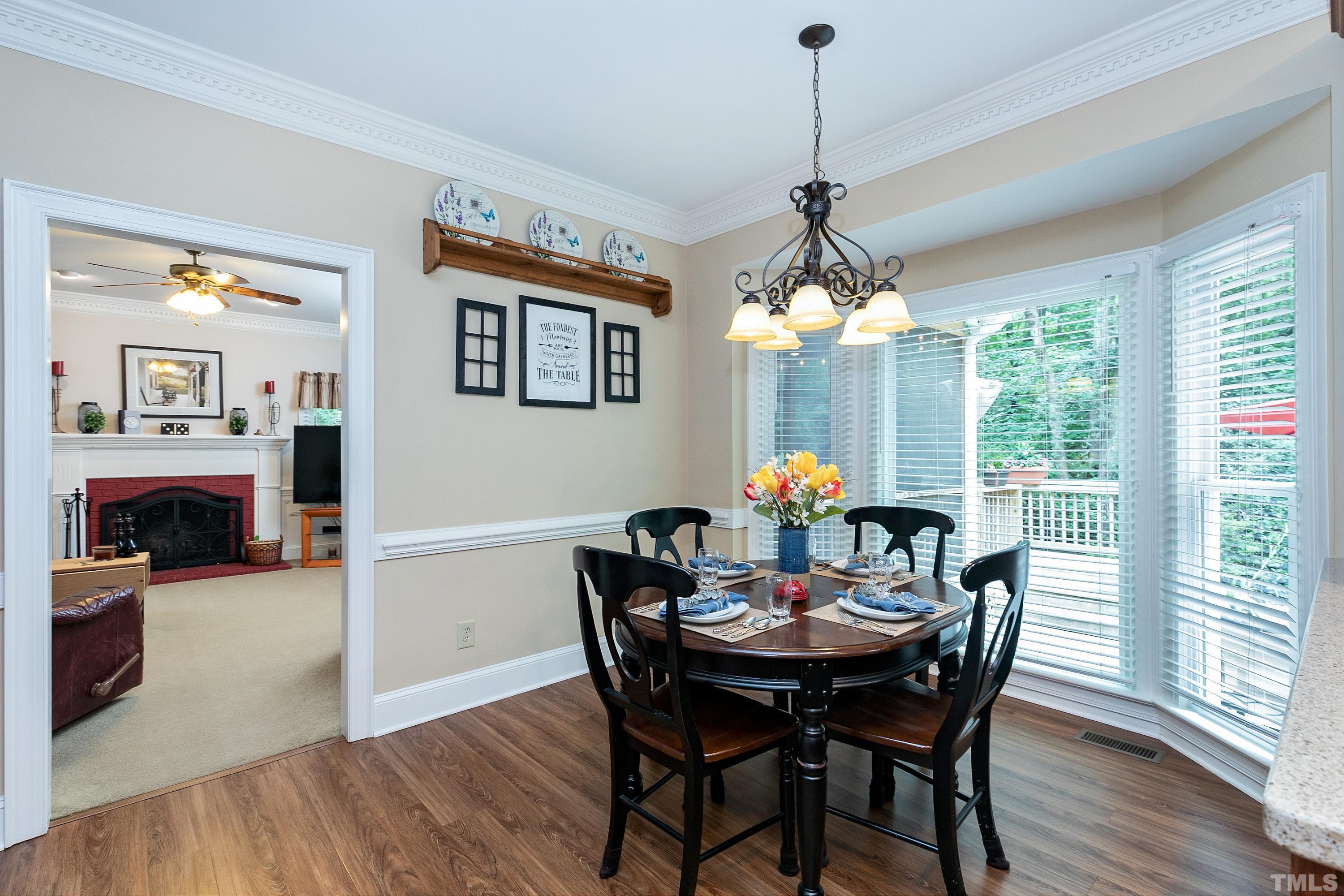 2905 Kenwick Court Raleigh, NC 27613 - Photo 16 of 45 a dining room with furniture a chandelier and wooden floor