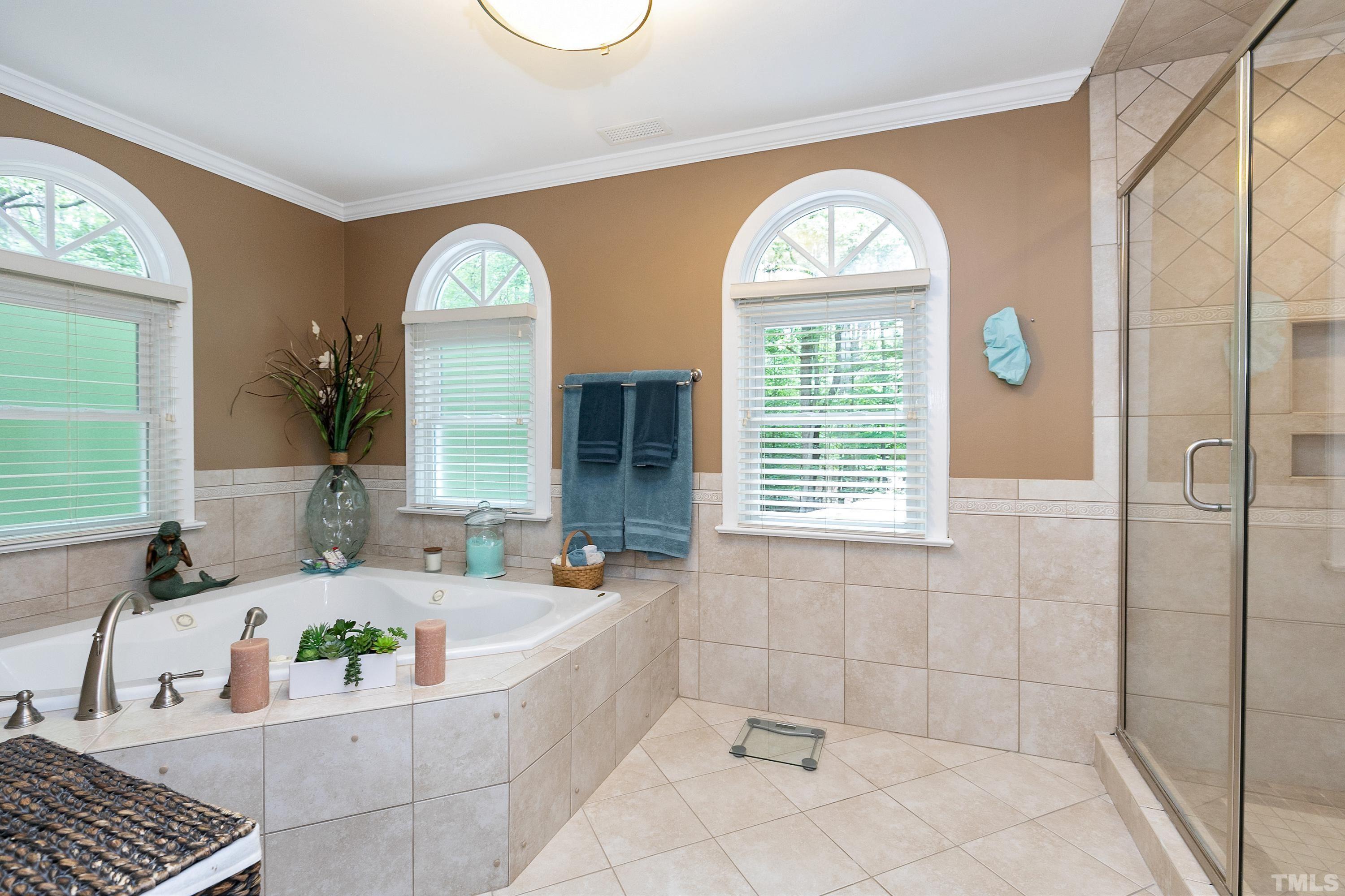 2905 Kenwick Court Raleigh, NC 27613 - Photo 25 of 45 a bathroom with a bathtub a window and a bathtub