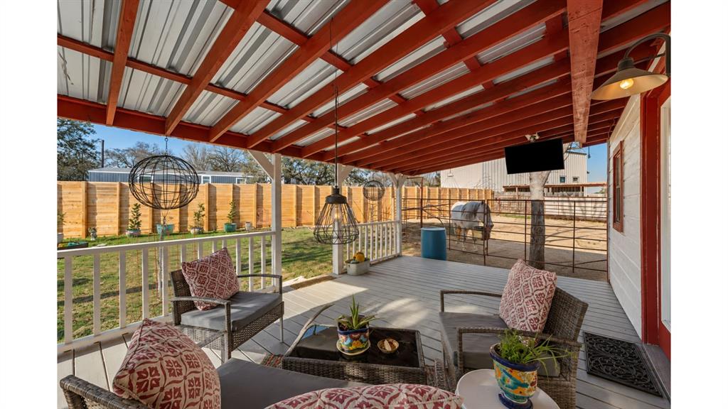 117 Reading Avenue North Center Point, TX 78010 - Photo 5 of 20 Covered outdoor patio featuring a metal roof, exposed red beams, and a mounted screen