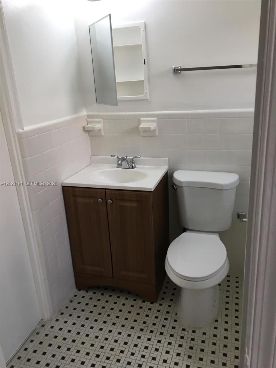 520 Southwest 4th Street, Unit 5 Miami, FL 33130 - Photo 5 of 11 a bathroom with a sink a toilet and a mirror