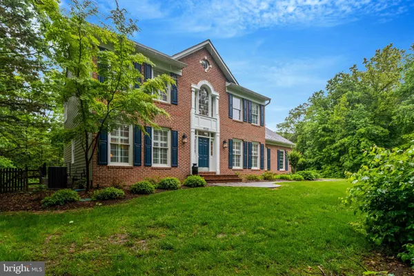 a front view of a house with a yard and trees