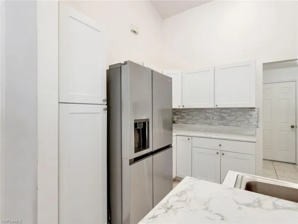 a kitchen with a refrigerator sink and cabinets