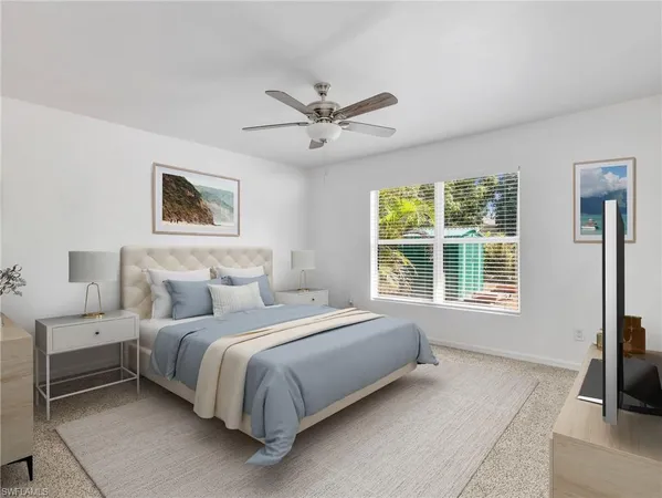 a bedroom with a bed a couch and a flat tv screen on the dresser