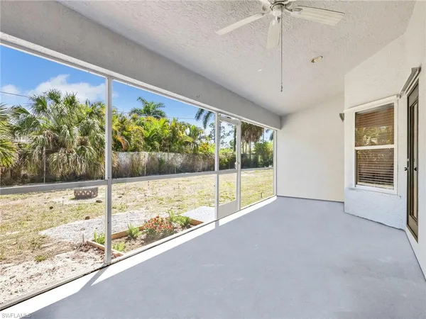 a view of a backyard with potted plants and large trees