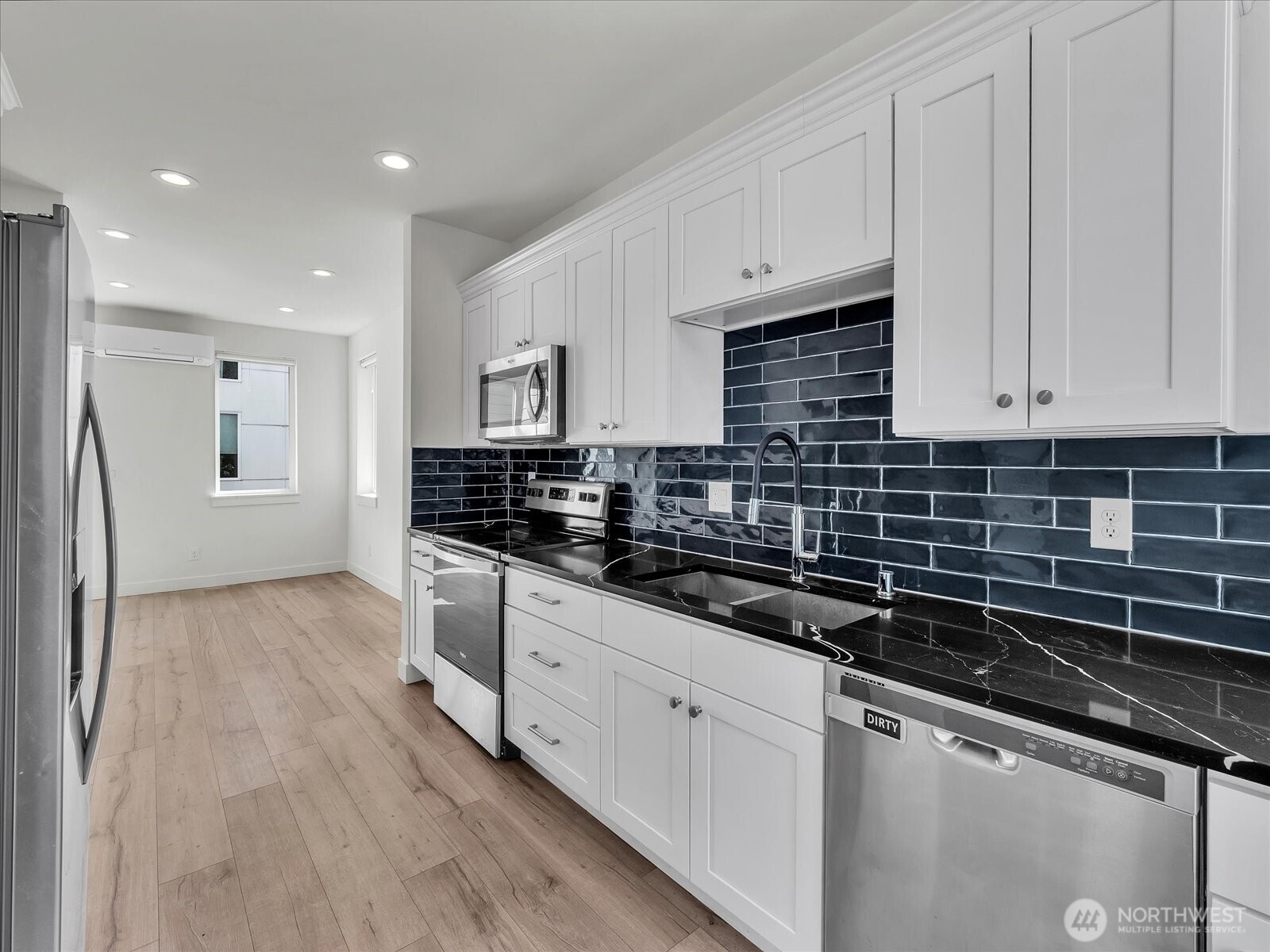 3628 14th Avenue South Seattle, WA 98144 - Photo 11 of 27 a kitchen with stainless steel appliances granite countertop a stove a sink and white cabinets