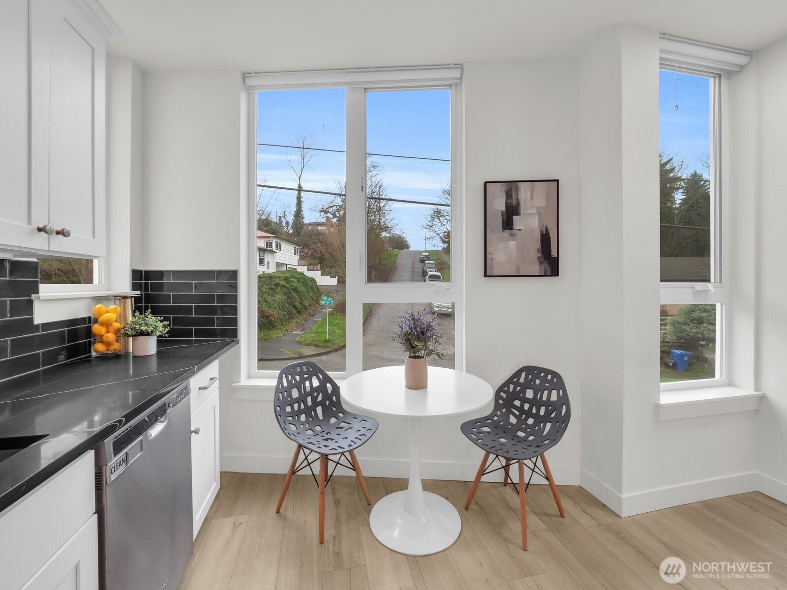 3628 14th Avenue South Seattle, WA 98144 - Photo 10 of 27 a kitchen with stainless steel appliances granite countertop a stove a refrigerator a dining table and chairs with wooden floor