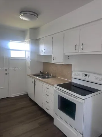 a kitchen with granite countertop white cabinets and white appliances
