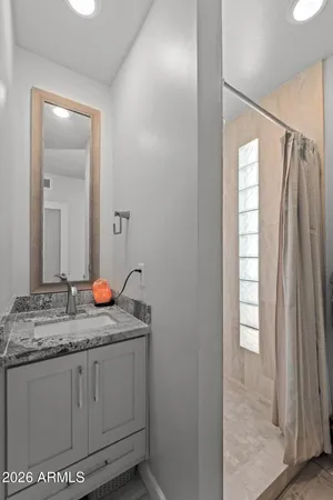 a bathroom with a granite countertop sink and a mirror