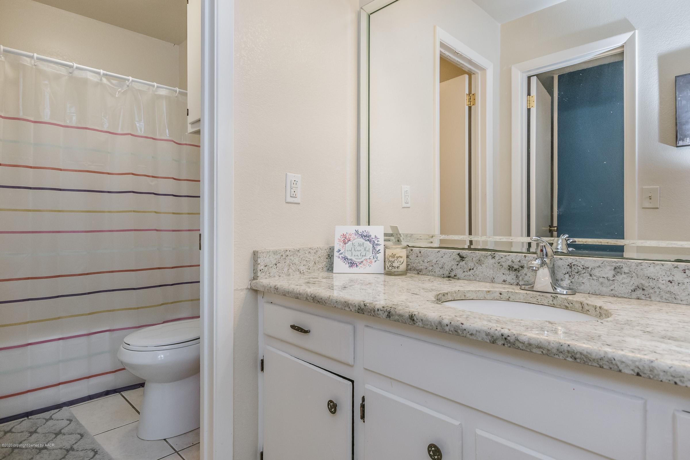 2818 Porter Drive Amarillo, TX 79110 - Photo 15 of 24 a bathroom with a granite countertop toilet sink and mirror