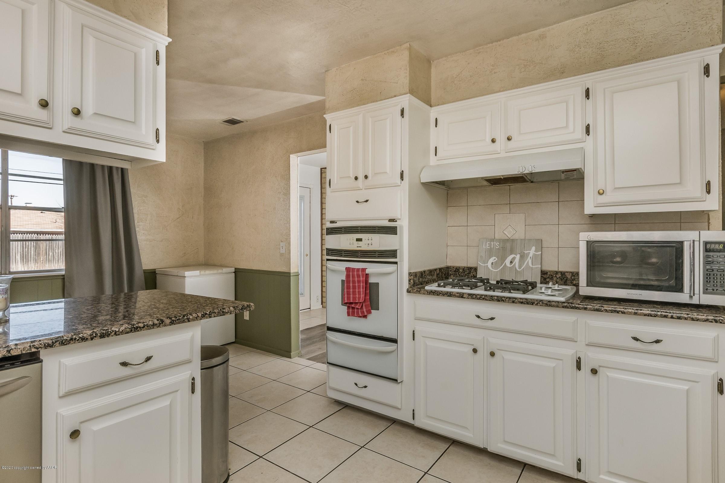 2818 Porter Drive Amarillo, TX 79110 - Photo 7 of 24 a kitchen with granite countertop white cabinets and stainless steel appliances