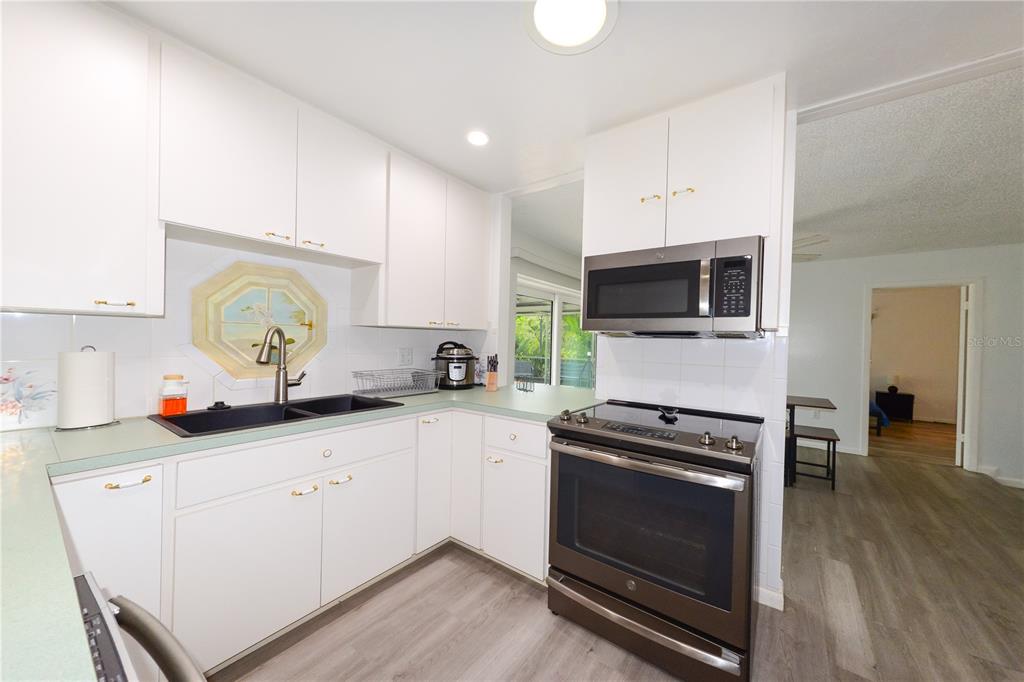 124 Caddy Road Rotonda West, FL 33947 - Photo 12 of 41 a kitchen with sink a microwave and cabinets