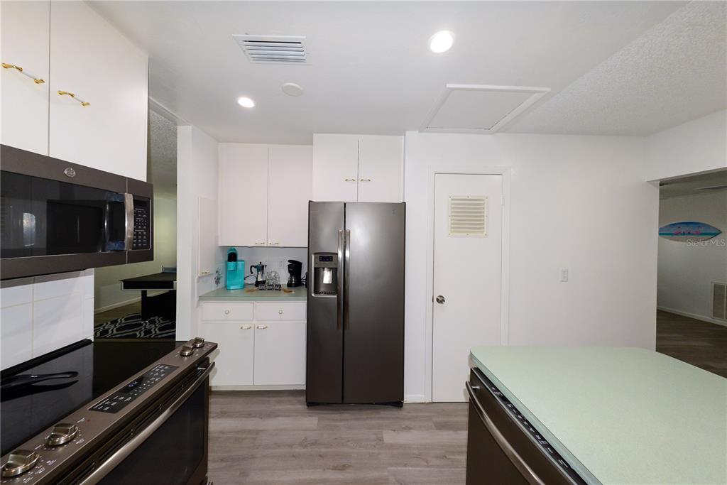 124 Caddy Road Rotonda West, FL 33947 - Photo 14 of 41 a kitchen with a refrigerator and a stove