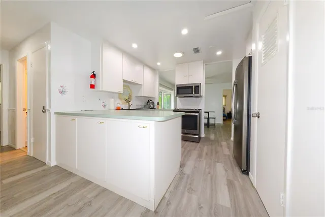 a kitchen with kitchen island a sink appliances and cabinets