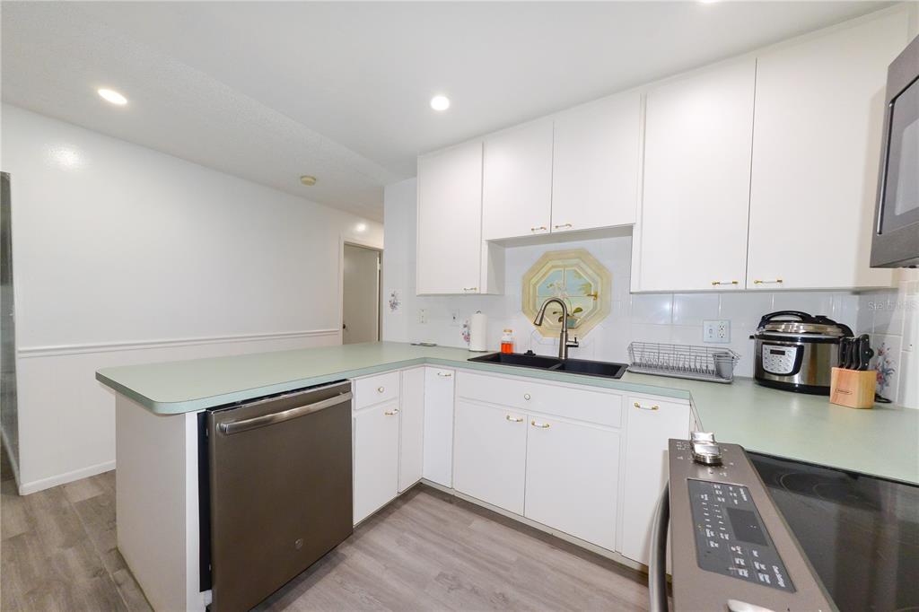 124 Caddy Road Rotonda West, FL 33947 - Photo 17 of 41 a kitchen with granite countertop white cabinets and a sink
