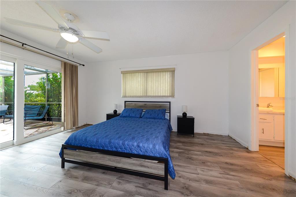 124 Caddy Road Rotonda West, FL 33947 - Photo 23 of 41 a bedroom with a bed and a large window with outer view
