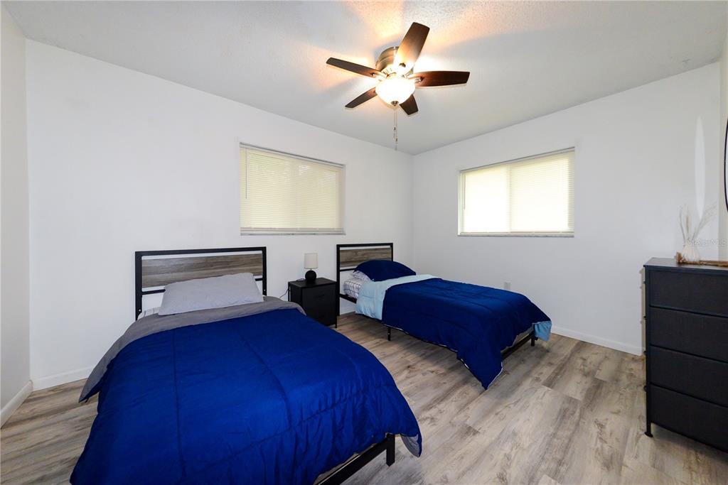 124 Caddy Road Rotonda West, FL 33947 - Photo 37 of 41 a bedroom with two beds and a chandelier