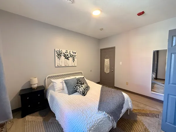 a bedroom with a bed and wooden floor