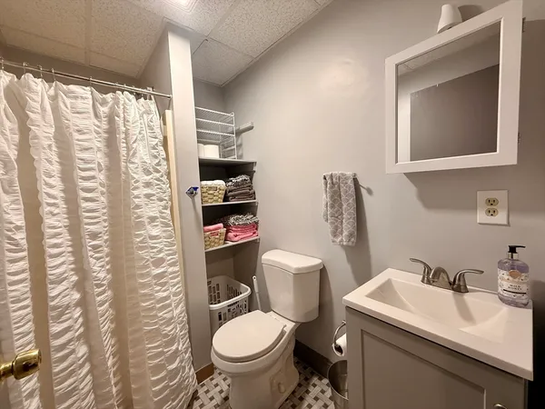 a bathroom with a toilet sink and mirror