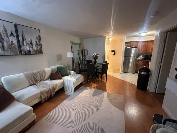 a living room with furniture and a view of kitchen