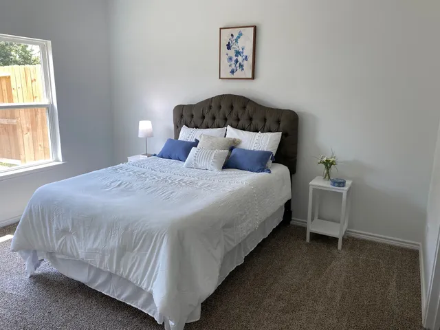 a bed sitting in a bedroom next to a window