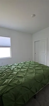 a bed sitting in a bedroom next to a window