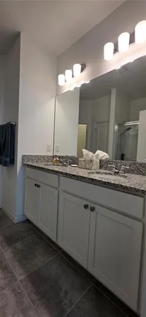 a bathroom with a granite countertop sink and a mirror