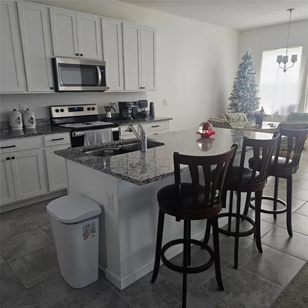 a kitchen with a table chairs stove and cabinets