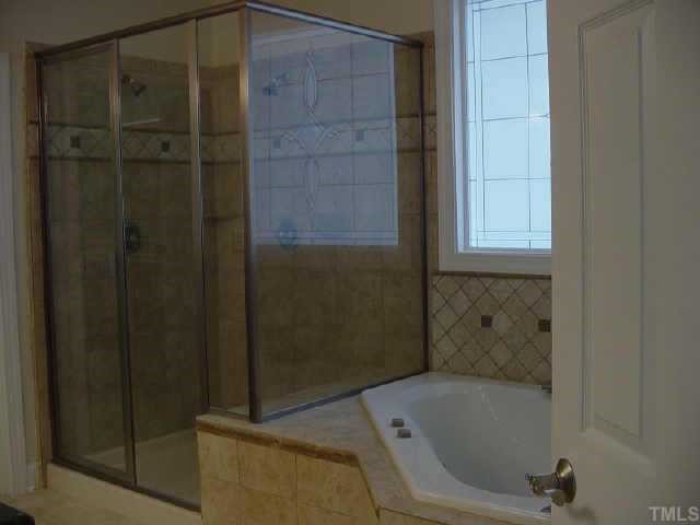 7224 Spring Meadow Lane Raleigh, NC 27606 - Photo 4 of 10 View of Master Bath shower and tub. Notice dual shower heads & extra tall enclosure with seat/shelf. Large corner spa tub. Brushed Nickel finishes!