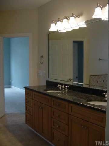 7224 Spring Meadow Lane Raleigh, NC 27606 - Photo 5 of 10 View of Master Bath lavatory area showing beautiful granite top (butterfly verde). Peek into closet showing full length mirror in closet!