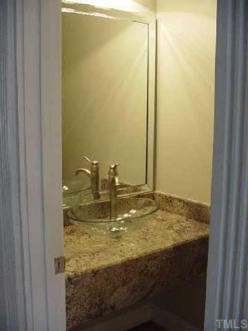7224 Spring Meadow Lane Raleigh, NC 27606 - Photo 7 of 10 Peak of powder room showing beautiful granite countertop and vessel sink.