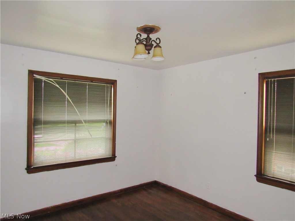 4067 East 187th Street Cleveland, OH 44122 - Photo 10 of 26 Wood-finish flooring with coordinating trim, two windows with wood frames, and a ceiling-mounted light fixture