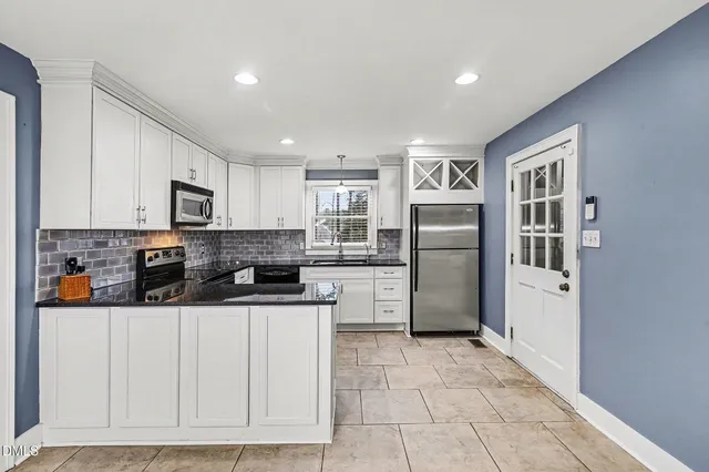 a kitchen with stainless steel appliances granite countertop a refrigerator and a stove top oven
