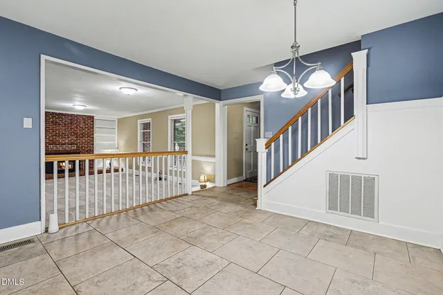 a view of an entryway wooden floor and chandelier