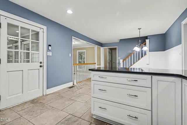 a view of a kitchen with wooden floor electronic appliances and furniture