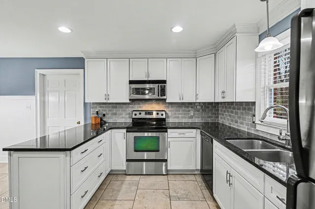 a kitchen with granite countertop white cabinets white stainless steel appliances and a sink