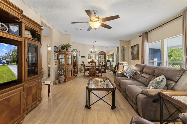 a living room with furniture a ceiling fan and a flat screen tv