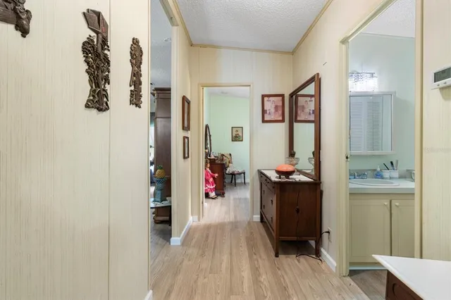 a view of a hallway with wooden floor and living room
