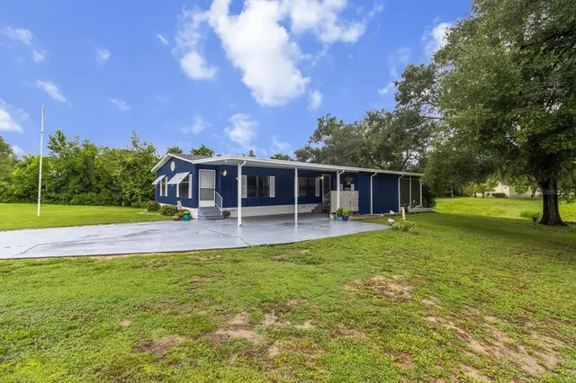 a view of house with yard and swimming pool