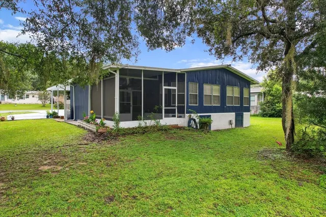 a view of a house with backyard and a tree