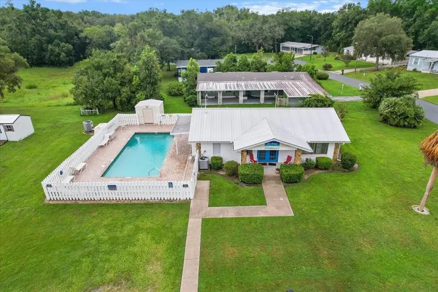 a aerial view of a house with a yard table and chairs