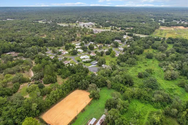 an aerial view of a houses with a yard and lake view