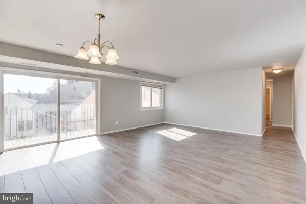 a view of a livingroom with wooden floor and a chandelier