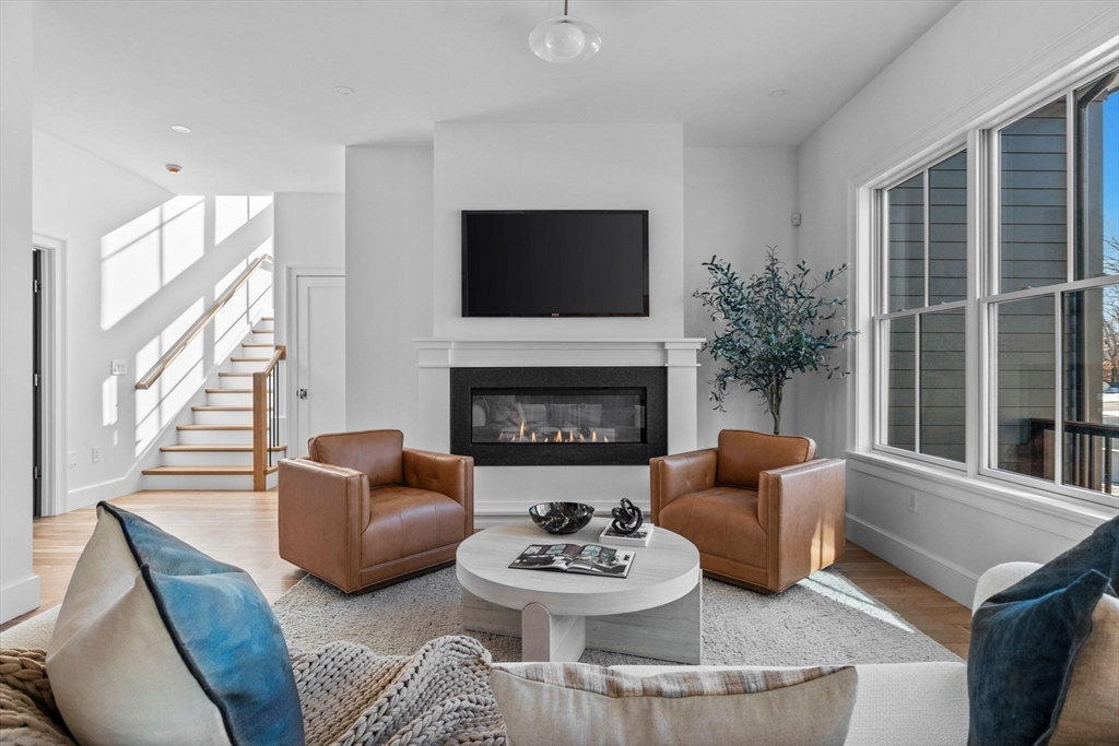 8 Common Court Lexington, MA 02421 - Photo 5 of 18 a living room with furniture a fireplace and a flat screen tv