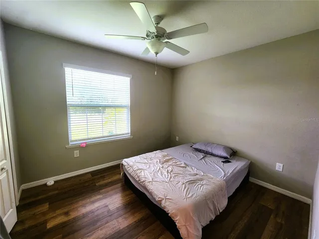 a bathroom with a granite countertop bathtub shower sink vanity mirror and toilet