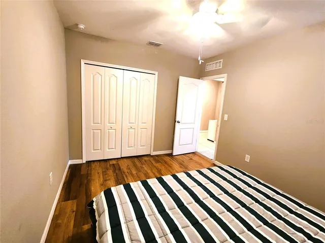 a view of a bedroom with wooden floor