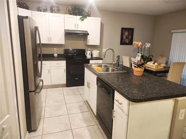 a kitchen with a sink a refrigerator and a stove